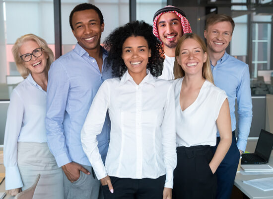 Smiling young mixed race female leader standing looking at camera with diverse team people, happy african american employee business coach millennial professional with office workers group portrait